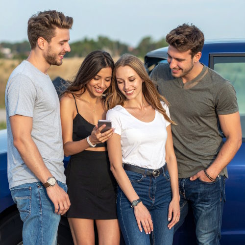 Freunde berechnen ihre Kraftstoffkosten über ein Smartphone